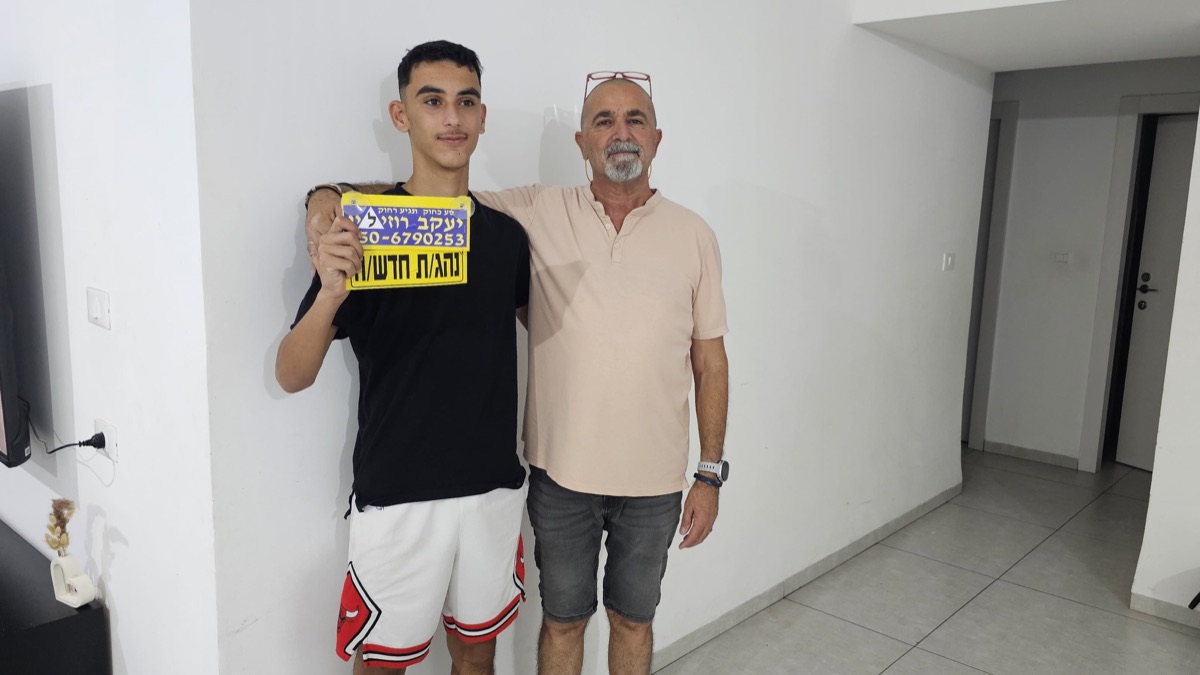 תלמיד עם שלט נהג חדש לאחר מעבר הטסט